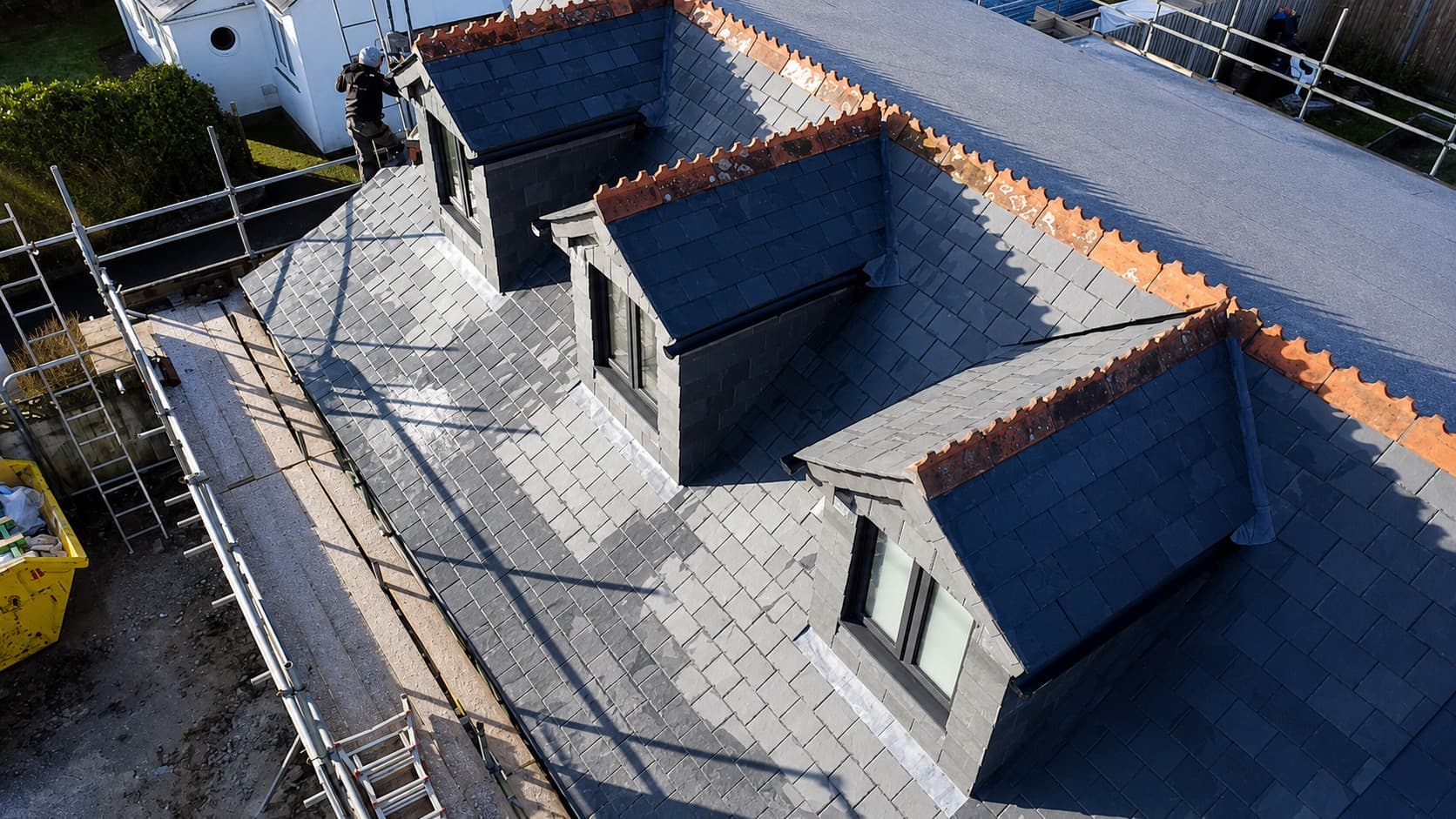 Aerial view of a new slate roof with dormer windows and flat roof section in Cornwall by NL Roofing